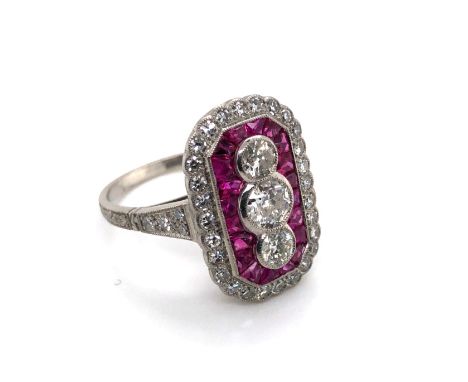 AN ART DECO STYLE RUBY AND DIAMOND PANEL RING. THE THREE CENTRAL OLD CUT DIAMONDS APPROX ESTIMATED TOTAL WEIGHT 0.70cts, SURR