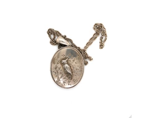 A VINTAGE PORTRAIT LOCKET THE OUTER COVER DEPICTING A PARAKEET ON A BRANCH, SUSPENDED ON A PRICE OF WALES CHAIN. UNHALLMARKED