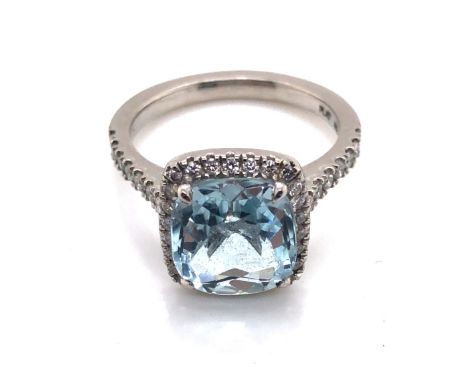 A CUSHION CUT AQUAMARINE AND DIAMOND HALO RING. THE SHANK STAMPED PLAT 950, AND ASSESSED AS PLATINUM. THE AQUAMARINE APPROX 9