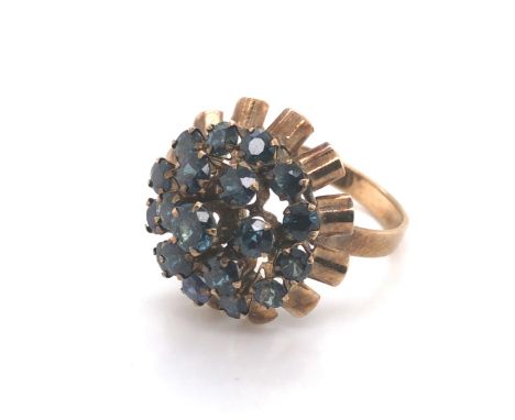 A VINTAGE CIRCA 1970's ASCENDING GEMSET CLUSTER RING. THE THREE GREENISH BLUE SAPPHIRE TIERS WITH ROUND BRILLIANT CUT CLAW SE