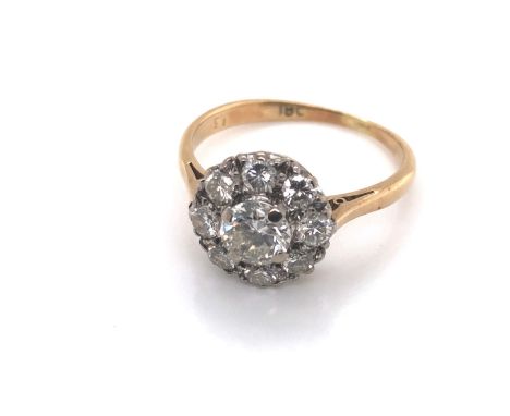 A VINTAGE DIAMOND CLUSTER RING. THE CENTRE DIAMOND SURROUND BY A HALO OF EIGHT FURTHER DIAMONDS. THE INSIDE SHANK STAMPED 18,