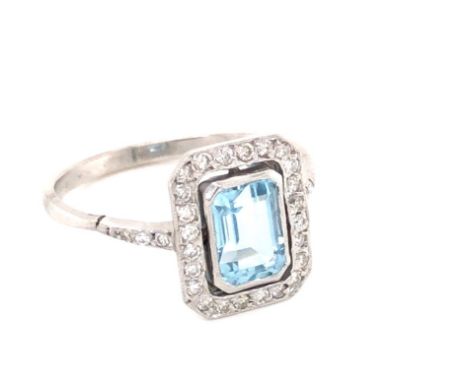 AN AQUAMARINE AND DIAMOND HALO SET DRESS RING. THE CENTRAL AQUAMARINE IN A BEZEL SETTING SURROUNDED BY A HALO OF GRAIN SET DI