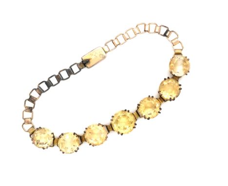 A VINTAGE CITRINE QUARTZ COSTUME BRACELET. FEATURING SEVEN GRADUATED CITRINE'S IN DOUBLE FOUR CLAW SETTINGS. LENGHT 20cms.
