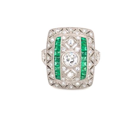 AN EMERALD AND DIAMOND ART DECO STYLE PANEL RING. THE CENTRAL DIAMOND AND OLD CUT APPROX WEIGHT 0.40cts, SURROUNDED BY A FILI