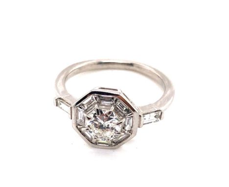 A DIAMOND SET OCTAGONAL HEAD UNUSUAL CLUSTER RING. UNHALLMARKED AND ASSESSED AS PLATINUM. THE CENTRAL DIAMOND APPROX 0.56cts,