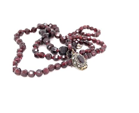 A VINTAGE GRADUATED KNOTTED ROW OF FACETED GARNET BEADS STUNG ON A FILIGREE ALMANDINE GARNET CLASP STAMPED CHINA, COMPLETE WI