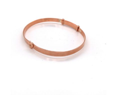 A LADIES SILVER AND ROSE GOLD PLATED EXPANDING BANGLE WITH A HEART MOTIF. WEIGHT 7.03grms. 