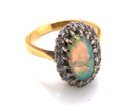 AN 18ct YELLOW GOLD ANTIQUE OPAL AND DIAMOND RING. THE OVAL OPAL IN A MULTI CLAW SETTING SURROUND BY A CLUSTER OF OLD CUT DIA