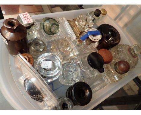 Shelf of predominantly glass inkwells including advertising example