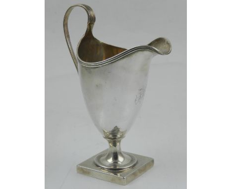 A silver helmet-shaped cream jug raised on square base, hallmarked London 1796, bears makers mark Peter & Ann Bateman.