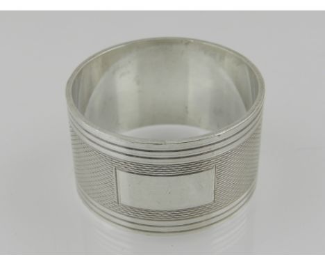 A Britannia standard heavy silver napkin ring, having engine turned decoration, with vacant cartouche, hallmarked Birmingham 