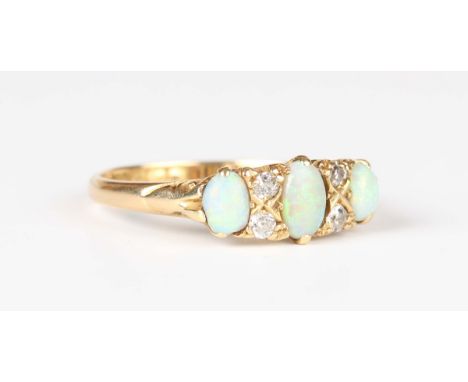 An 18ct gold, opal and diamond ring, mounted with three oval opals and two pairs of cushion cut diamonds, Birmingham 1918, we