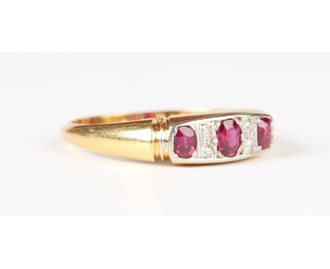 A gold and platinum, ruby and diamond ring, mounted with three oval cut rubies alternating with two pairs of circular cut dia