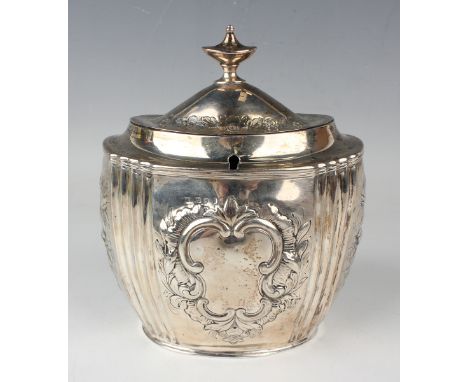 A George III silver oval tea caddy, later repoussé decorated with panels of flowers and a scroll cartouche, the hinged lid wi