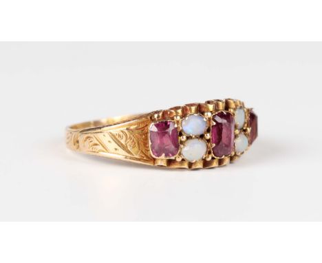 A 15ct gold, opal and garnet ring, mounted with four opals and three garnets, the shoulders with engraved decoration, Birming