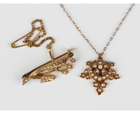 An Edwardian gold and seed pearl pendant, designed as a crescent enclosing a flowerhead within a surround of three trefoils, 