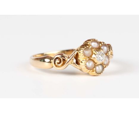 A gold, diamond and half-pearl cluster ring, mounted with a cushion cut diamond within a surround of six half-pearls between 