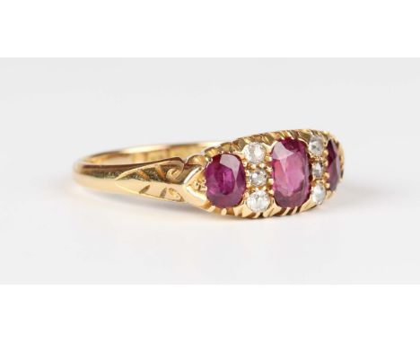 An Edwardian 18ct gold, ruby and diamond ring, mounted with a graduated row of three rubies alternating with two rows of thre