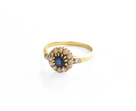 A Sapphire and Diamond Cluster Ring, the round cut sapphire within a border of old cut diamonds, in yellow claw settings, to 