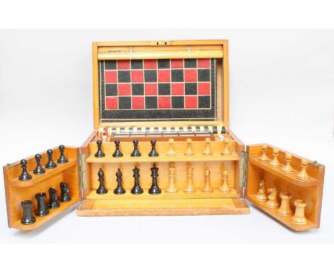 An Edwardian Pine Games Compendium containing, a boxwood and boxwood and ebony Staunton chess set, draughts, cribbage marker,