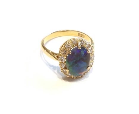 A Black Opal and Diamond Cluster Ring, the oval cabochon opal within a border of eight-cut diamonds, in yellow claw settings,