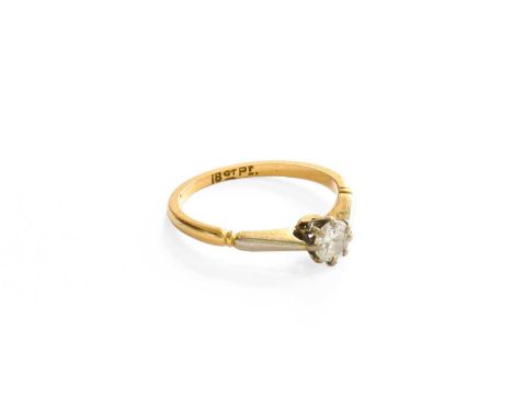 A Diamond Solitaire Ring, the round brilliant cut diamond in a white claw setting, to a tapered shoulder yellow plain polishe