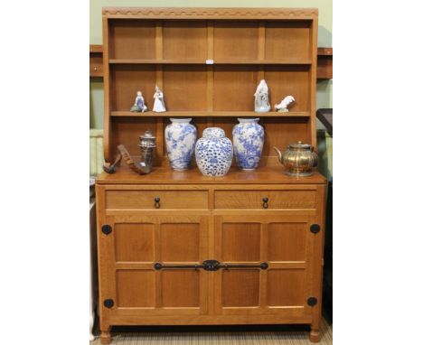 A lovely Mouseman Welsh Dresser with an open rack with two fixed shelves above a base unit with an adzed top over two drawers