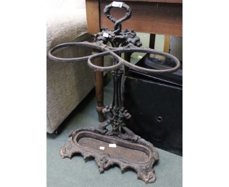 A cast metal three hooped stick/umbrella stand with original lift out drip tray
