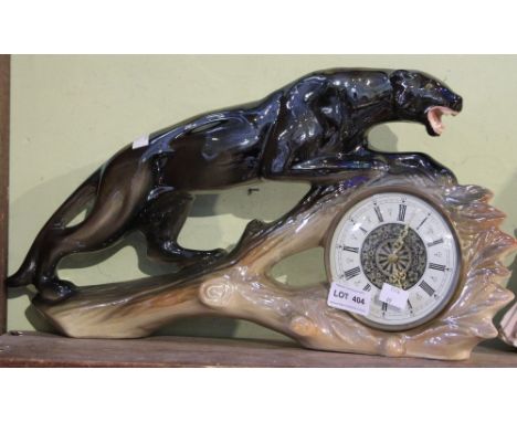 A mantle clock in the form of a ceramic jaguar