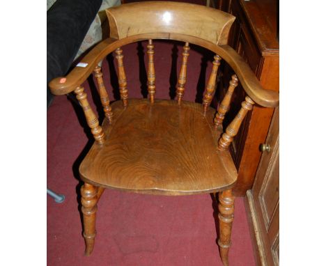 An early 20th century elm seat and beech stick back captain's chair