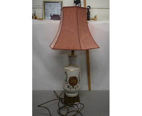 A cream and gilt glazed table lamp with peach damask shade
