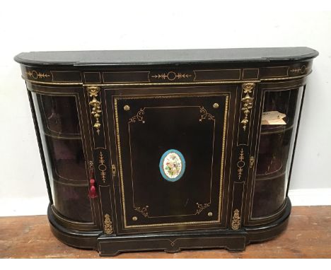 An ebonised Victorian Credenza with gilt-metal mounts, the central door with oval 'Sevre' style floral porcelain panel, openi