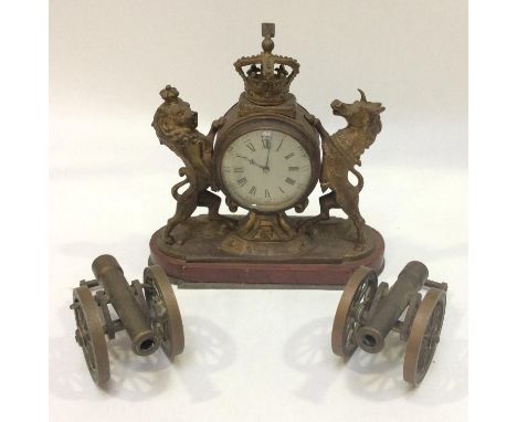 A small gilt brass mantel clock modelled as the Lion and Unicorn from the Royal Coat of Arms, supporting the circular timepie