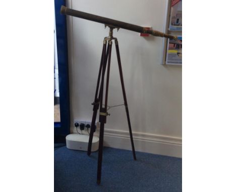 A large brass floor standing telescope with wooden and brass bound tripod 