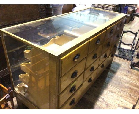 A glazed light oak haberdashery shop counter, with sixteen drawers, 152x59x92cm 