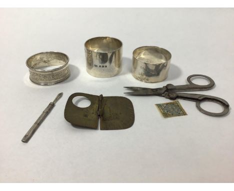 Three various silver napkin rings (2.45ozt), together with a white metal toothpick, a Victorian folding sundial marked Birmin