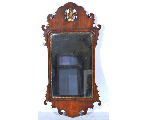 Walnut wall mirror, in the Chippendale style, fretted frame, fleur de lys pediment, arched glass, height 97cm, width 49cm.