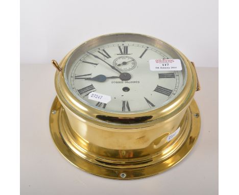 Brass cased ships clock, white enamel dial, bears signature Dobbie-McInnis, diameter 20cm.