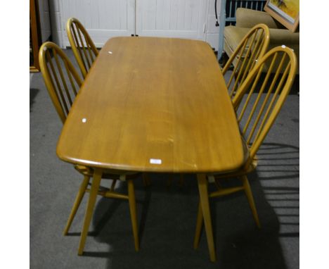 An Ercol elm and beech dining suite, comprising dining table, with a rectangular top, shaped rounded corners, splayed legs, t