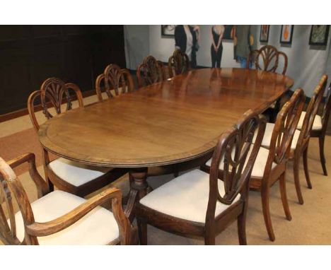 MAHOGANY CROSSBANDED EXTENDING TWIN PILLAR DINING TABLE OF GEORGE III DESIGN with one wide traditional leaf on vase shaped pi