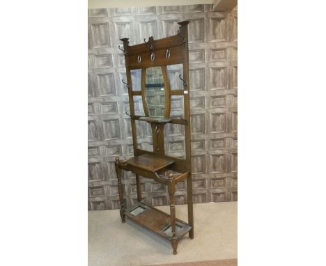 EDWARDIAN OAK HALL STANDthe back with pierced panel and shaped bevelled mirror with open shelf below, the base with hinged co