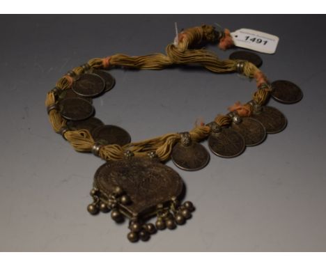 An Eastern silver trade necklace, mounted with a lotus-shaped pendant and twelve Gothic and other Victorian florins, 40cm lon
