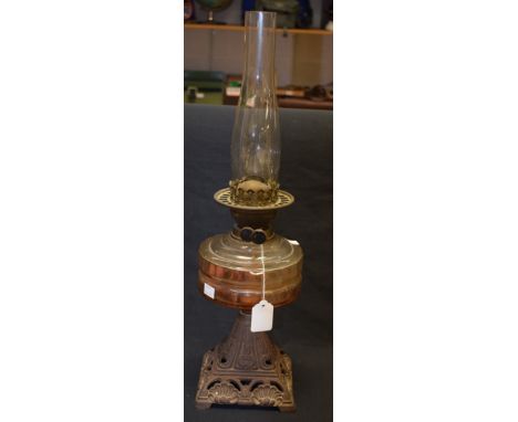 A Victorian cast iron and clear glass oil lamp, clear glass reservoir, pyramid base