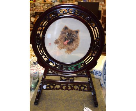 A Chinese circular glass panel, reverse painted with a portrait of a dog, hardwood stand, silk box