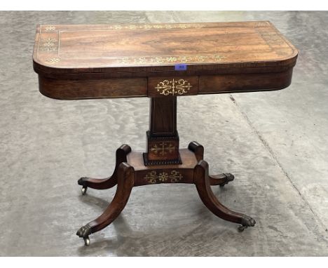 A Regency rosewood cut brass and line inlaid card table on quadripartite outswept support. 36' wide