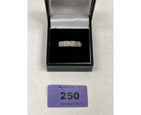 A nine stone diamond channel set ring. In white gold marked 18ct. 6g gross. Size R