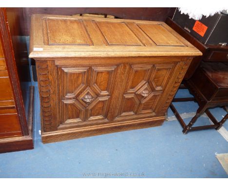 A reproduction Oak Linen Chest having three panel lid over twin panel front, each panel having applied geometric moulding aro