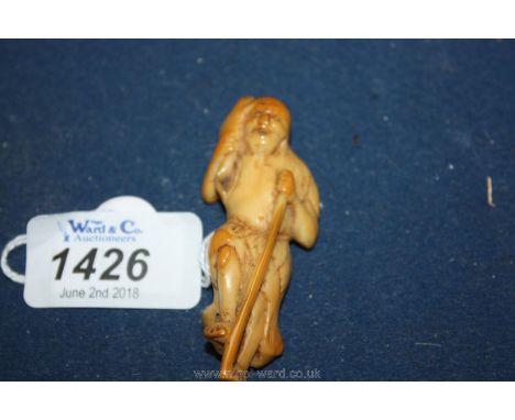 An Edo period Japanese carved Ivory Netsuke featuring Gama Sennin standing on one foot with a three legged toad on his should