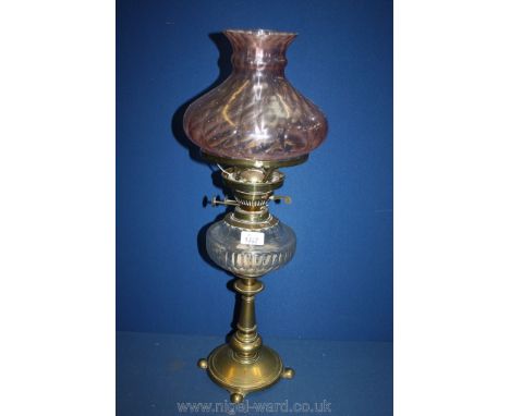 A Brass Oil Lamp with cranberry glass coloured shade and funnel