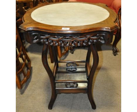 A Chinese rosewood and marble top centre table,
having a shaped top with a carved and pierced frieze with shelf below, raised